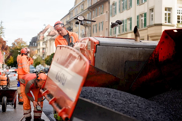 Road construction workers operating an asphalt paver in Bern – documenting modern construction processes within the Sponge City initiative.