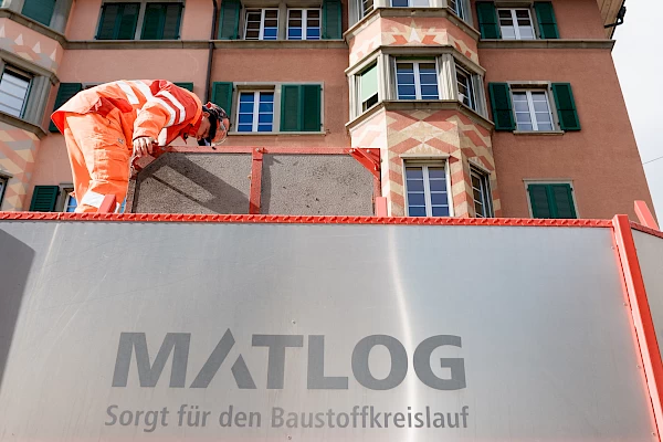 Construction worker on a MATLOG container in Bern – symbolizing circular economy and sustainable material use in the Sponge City project.