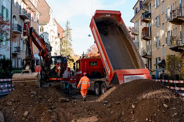 Dump truck unloading soil at a construction site in Bern – excavation work as part of sustainable urban development.