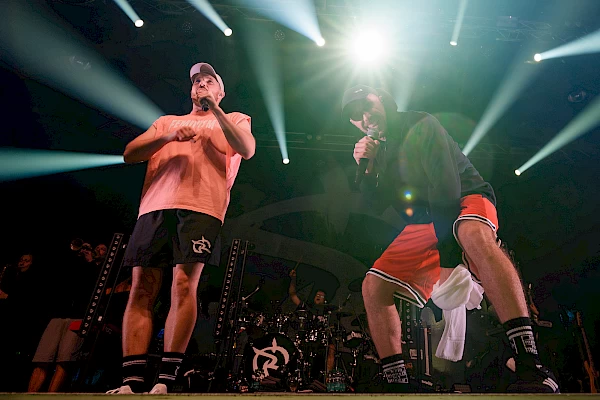 Singers under stage lights during an energetic live concert in Bern