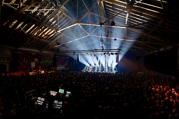 Stage lights and smoke create atmosphere during a live performance in Bern